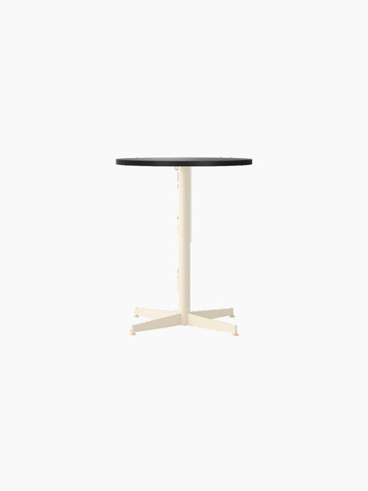 Front view of the Nook Dining Table with a round charcoal linoleum top and an ivory powder-coated steel four-star base.