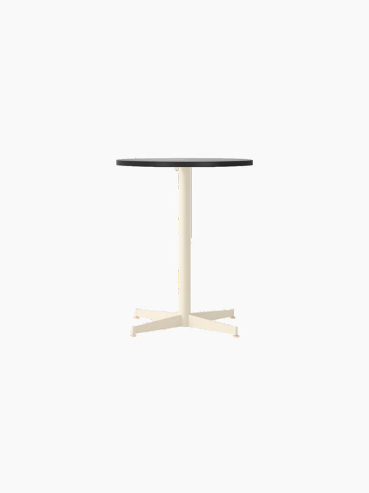 Front view of the Nook Dining Table with a round black oak top and an ivory powder-coated steel stem and four-star base.
