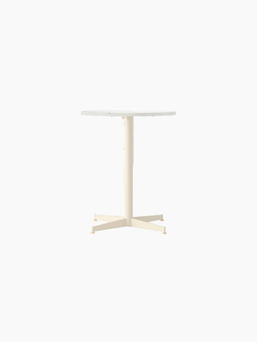 Front view of the Nook Dining Table with a round Estremoz marble top and an ivory powder-coated four-star pedestal base.