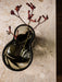 A top-down view of the dark, rippled glass Aer Vase holding a stem of fuzzy, deep red Kangaroo Paws on a marble surface.
