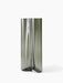 An angled view of the large Aer Vase. The tall, sculptural form is crafted from smoky grey glass with a rippling effect.