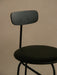 A close-up of the Afteroom Bar Chair in black painted veneer, showing the curved backrest and seat against a neutral wall.