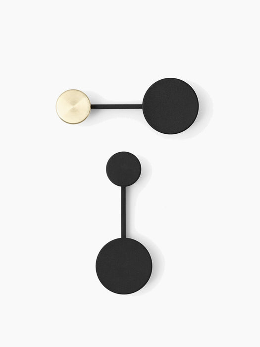 Two small, black Afteroom Coat Hangers on a white background. One horizontally with a brass detail, the other vertically.