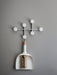 The white Sweeper & Funnel dustpan and brush hangs from the white Afteroom Coat Hanger against a simple grey wall.