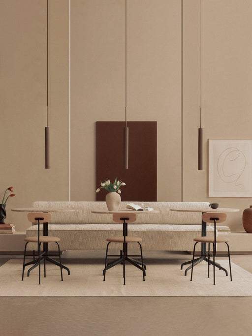 Three Afteroom Dining Chairs at Harbour Column Tables before an Eave Dining Banquette, lit by Tubulaire Pendant lights.