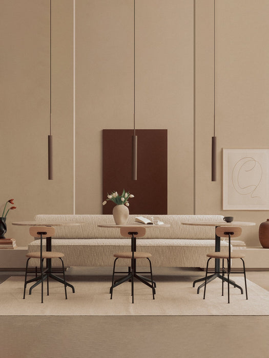 Three Afteroom Dining Chairs at Harbour Column Tables before an Eave Dining Banquette, lit by Tubulaire Pendant lights.