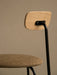 A close-up of the Afteroom Dining Chair, highlighting the natural oak backrest, black steel frame, and textured bouclé seat.