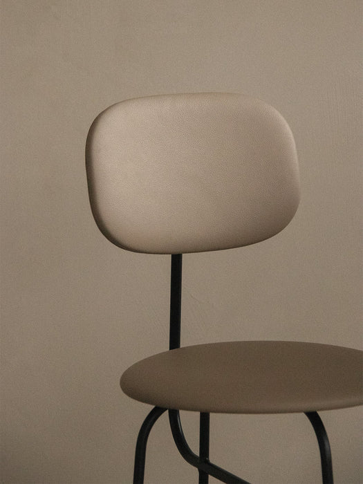 A close-up of the Afteroom Counter Chair Plus, showing its beige upholstered backrest and seat against a neutral wall.