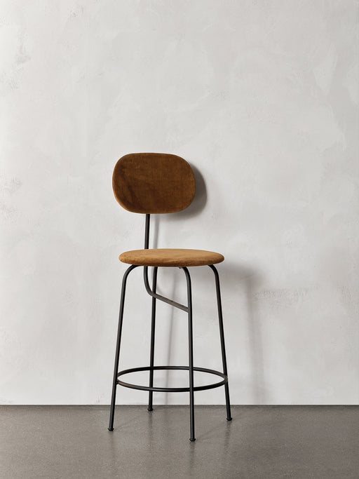 A frontal view of the Afteroom Counter Chair Plus, featuring brown upholstery and a slender black powder-coated steel frame.