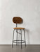A frontal view of the Afteroom Counter Chair Plus, featuring brown upholstery and a slender black powder-coated steel frame.