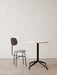A grey patterned Afteroom Dining Chair Plus with black frame stands next to a Harbour Column Dining Table with a marble top.