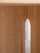 Detailed close-up of the Androgyne Dining Table base, showcasing the rich texture of natural oak and its arched cutout.
