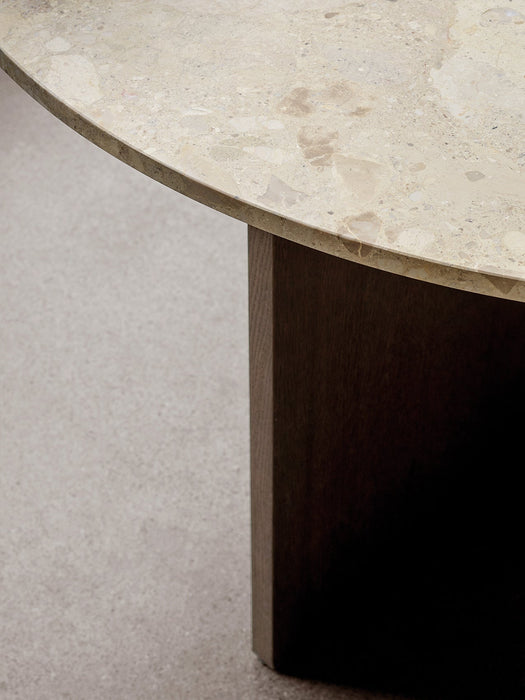 A close-up shot of the Androgyne Dining Table, showcasing the detailed texture of the round Kunis Breccia stone tabletop.