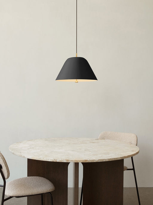 A black Levitate Pendant hangs over the round Androgyne Dining Table with a marble top, flanked by two upholstered Co Chairs.