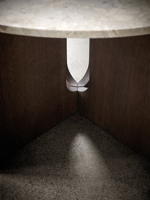 A detailed close-up of the Androgyne Dining Table's base, showing the dark oak wood and unique cut-out on a terrazzo floor.