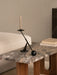 A black Interconnect Candle Holder on an Androgyne Lounge Table with a Grey Galaxy marble top and dark wood base.
