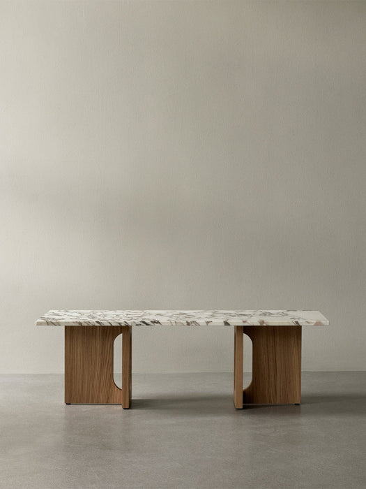 Front view of the Androgyne Lounge Table with a veined marble top on a natural oak wood base against a plain background.