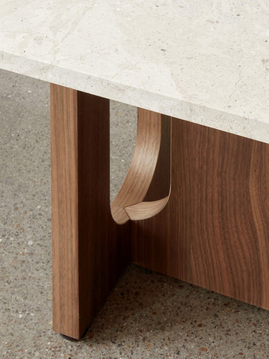 Close-up shot of the Androgyne Lounge Table, detailing the rich grain of the walnut wood base and its curved cut-out design.