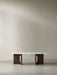 Androgyne Lounge Table with a white marble top and dark stained oak base, viewed front-on in a minimalist room.