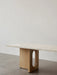 Side view of the Androgyne Lounge Table with a Kunis Breccia stone top and a natural oak base featuring an oval cutout.