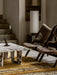 The Androgyne Lounge Table in Calacatta Viola marble, set on a yellow and grey rug next to two brown shearling chairs.