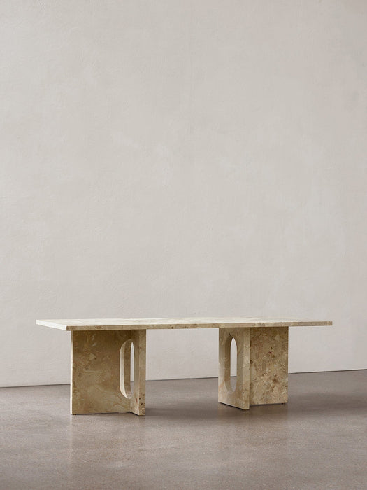 A front-facing shot of the Androgyne Lounge Table in Kunis Breccia stone, set against a neutral wall on a grey floor.