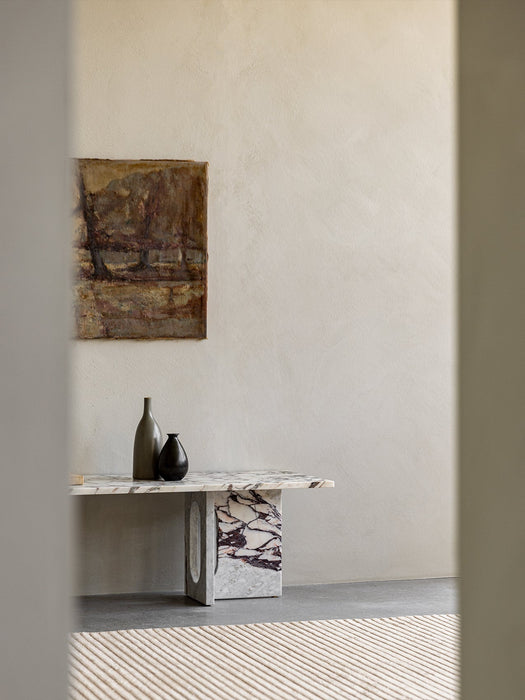 Androgyne Lounge Table in Calacatta Viola marble, styled with two vases, in a sunlit room with abstract art and a rug.