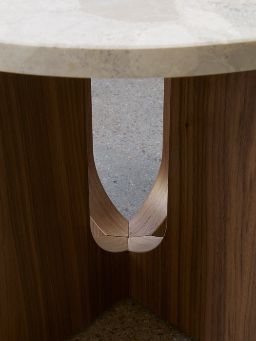 Close-up of the Androgyne Side Table, showing the U-shaped cutout and joinery of the walnut base under the Kunis Breccia top.