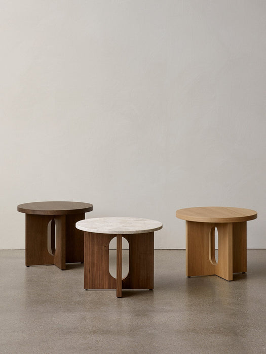 Three Androgyne Side Tables, Ø50, in dark oak, natural oak, and walnut with a stone top, on a concrete floor.