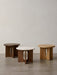 Three Androgyne Side Tables, Ø50, in dark oak, natural oak, and walnut with a stone top, on a concrete floor.