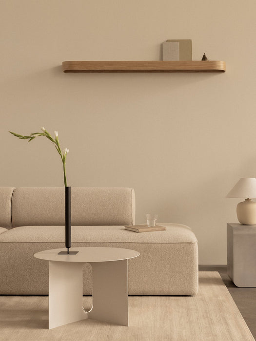 Minimalist living room with Androgyne Side Table, Eave Modular Sofa, Volume Side Table, and Epoch Shelf on a beige wall.
