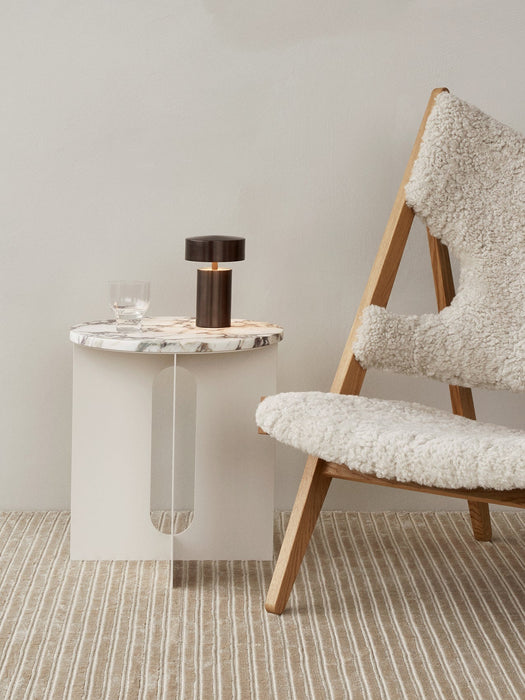 Androgyne Side Table with marble top and Column Table Lamp next to a shearling Knitting Chair on a Houkime Rug.