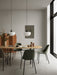 Two white Bank Pendants hanging over a wooden Snaregade Table with green Harbour Dining Chairs in a modern dining room.