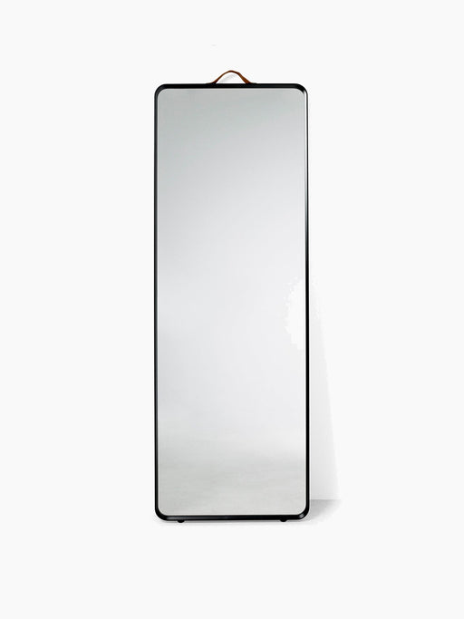The Norm Floor Mirror in black, a full-length rectangular mirror with rounded corners, a thin frame and a leather strap.