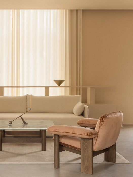 Beige living room with a pink Brasilia Lounge Chair, cream Offset Sofa, and Lounge Table with an Interconnect Candle Holder.