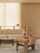 Beige living room with a pink Brasilia Lounge Chair, cream Offset Sofa, and Lounge Table with an Interconnect Candle Holder.