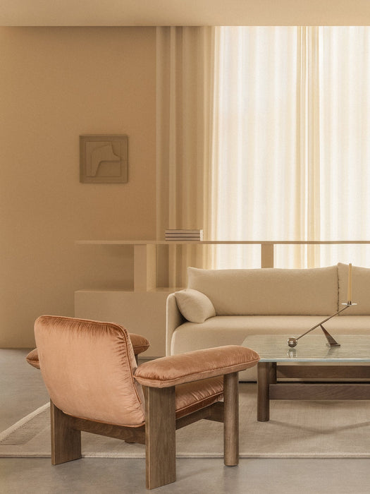 Beige living room with a rust velvet Brasilia Lounge Chair, Offset Sofa, glass Lounge Table, and Interconnect Candle Holder.