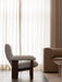 Side view of the Brasilia Lounge Chair with its dark wood frame and light fabric, set in a living room beside an Eave Sofa.