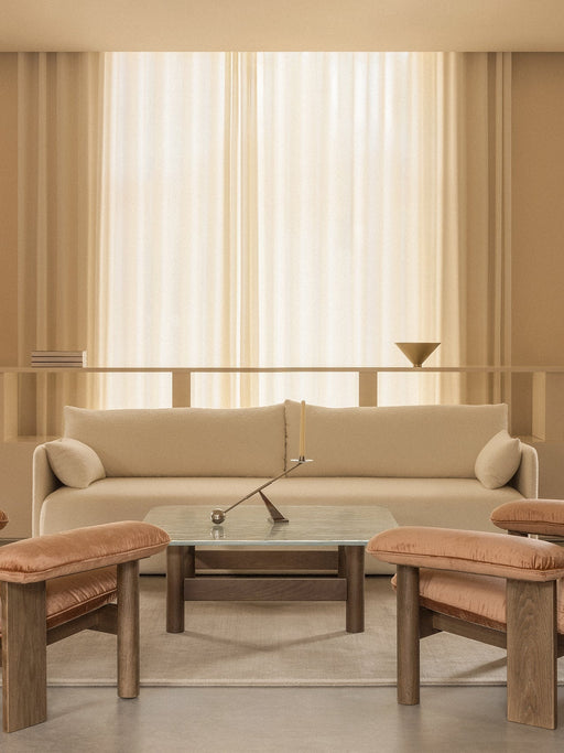 A warmly lit living room with a beige Offset Sofa, two Brasilia Lounge Chairs, and a central Brasilia Lounge Table.