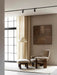 Brasilia Lounge Chair and Brasilia Ottoman on a Houkime Rug in a living room corner with a floor lamp and abstract art.