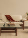 Close-up of Brasilia Lounge Table with Interconnect Candle Holder and books. In the background, a Brasilia Sofa in sheepskin.