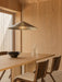 A wood-panelled dining room with a Chancery Pendant Lamp over an Androgyne Dining Table, Ready Chairs, and Triptych Bowls.