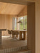 A wood-panelled dining room featuring an Androgyne Dining Table, Harbour Swivel Chairs, and a Chancery Pendant Lamp.