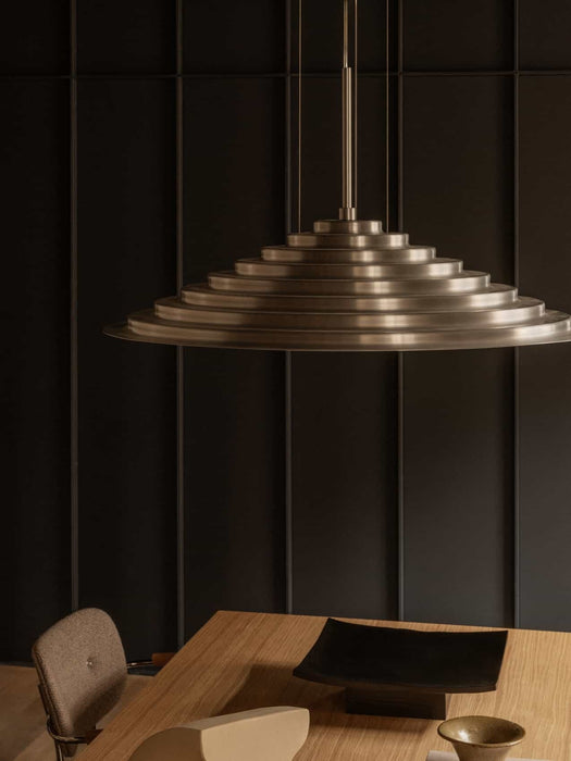 The brushed aluminium Chancery Pendant Lamp hangs over an Androgyne Dining Table, with a Co Task Chair seen to the side.