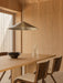 The Chancery Pendant Lamp hangs over an Androgyne Dining Table with Ready Chairs, a Triptych Bowl, and Bottle Carafe.