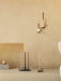 A collection of black metal Clip Candle Holders for wall and table use, holding various lit Spire and Twist Tapered Candles.