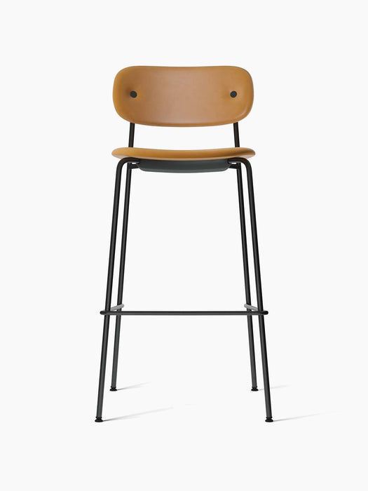 A front-on studio shot of the Co Bar Chair, upholstered in tan Dakar leather with a slender, black powder-coated steel frame.