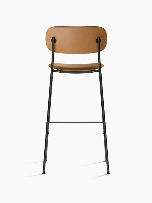 Back view of the Co Bar Chair, Fully Upholstered, showing its tan leather seat and backrest on a slender black steel frame.