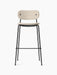 Front view of the Co Bar Chair with a black steel frame, footrest, and light Moss fabric upholstery on its seat and back.