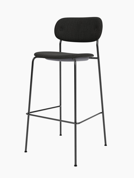 The Co Bar Chair, Fully Upholstered, has a slim black steel frame with a footrest, and dark seat and backrest.